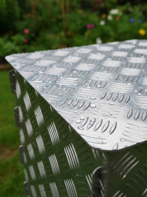 Alu Hocker mit Regentropen auf Oberfläche